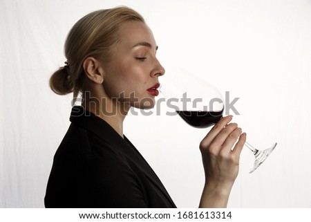 A sommelier girl tastes wine. On white background. Selective focus.