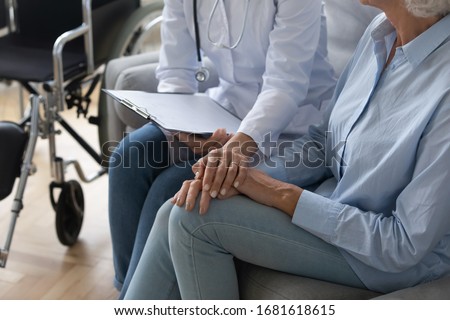 Close up of supportive female caregiver hold hand give help to disabled mature grandmother visit old patient at home, woman doctor support elderly retired lady on wheelchair, healthcare concept Royalty-Free Stock Photo #1681618615