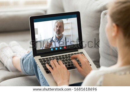 Young woman sit on couch at home have video call with doctor use wireless internet connection on laptop, female patient talk consult with physician online on webcam conference on computer Royalty-Free Stock Photo #1681618696