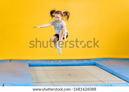 Happy little girl jumping on trampoline in fitness center Royalty-Free Stock Photo #1681626088