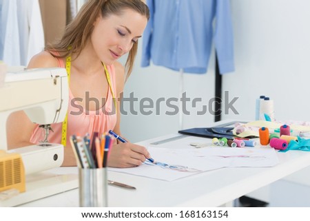 Young female fashion designer working on her designs in the studio