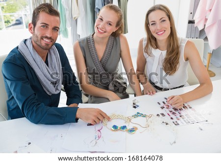 Portrait of three fashion designers discussing designs in a studio