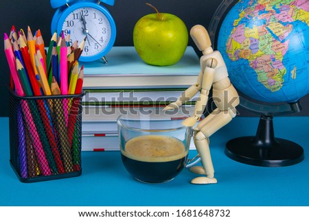 A stack of books with a globe, a glass of pencils, a clock apples and coffee.