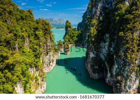 Aerial drone view of longtail boats around spectacular limestone fingers and karsts on a huge lake surrounded by jungle Royalty-Free Stock Photo #1681670377