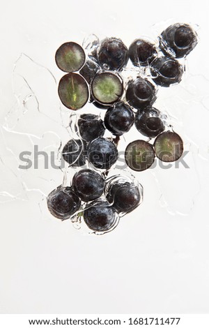 
Bunch of black grapes on white background. Splash effect.