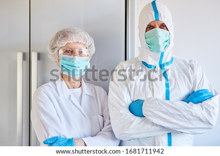 Disease control employees in protective clothing during coronavirus (Coivd-19) epidemic in a clinic Royalty-Free Stock Photo #1681711942