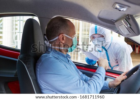 Drivers go to the coronavirus test in the drive-in at doctors in protective clothing Royalty-Free Stock Photo #1681711960