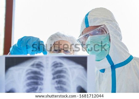 Medical doctor with X-ray image of the lungs of a Covid-19 patient in the intensive care unit