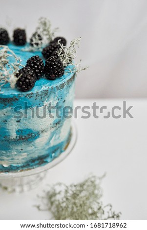 blue cake with berries on a white background on crystalstand