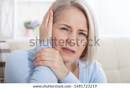 Tinnitus. Closeup up side profile sick female having ear pain touching her painful head. Concept photo with indicating location of the pain. Health care concept Royalty-Free Stock Photo #1681723219