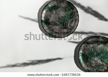 Beautiful handmade plates on a white background. Shadow from plants on a white background