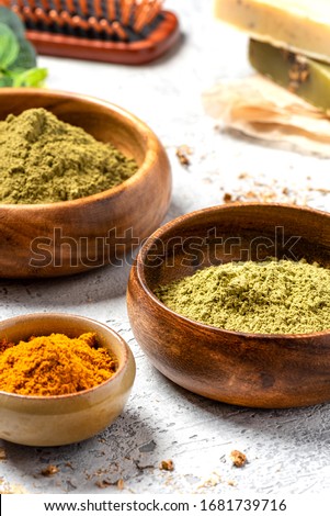 Ayurvedic hair care products. Henna, turmeric and neem powder in bowls on a grey background. Natural care and hair coloring.	