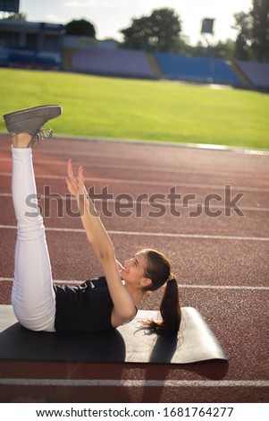 Girl athlete outdoors doing flexibility exercises.