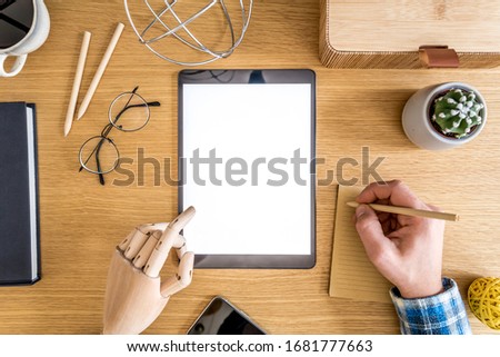 Stylish home office composition of businessman who are using mock up tablet screen, office supplies, cacti, phone, notes, plants and personal accessories in flat lay business concept. 