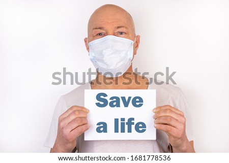A sick man holds a tablet with the text Save a life text. Medical concept.
