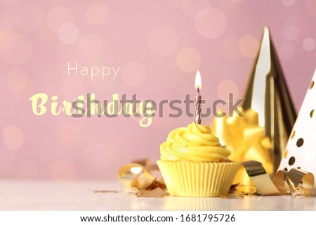 Delicious cupcake with burning candle and text Happy birthday on blurred background