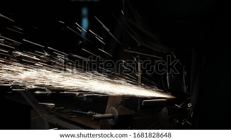 a worker at factory processes metal, sparks fly. close-up. Circular saw cuts metal in a workshop. man works on the conqueror. metalworking in a factory.