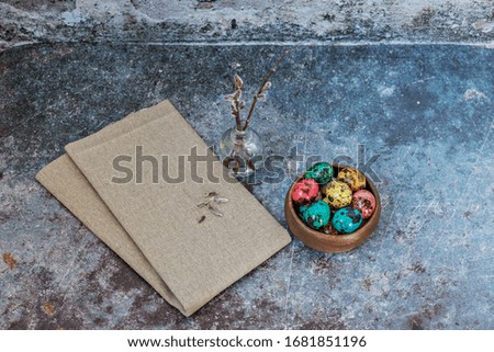 Happy Easter, quail colored spotted eggs in a wooden bowl on a linen towel and willow branches in a small vase, a symbol of the spring Orthodox and Catholic holiday

