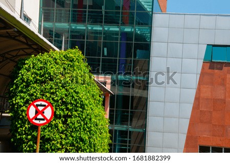 Do not park sign in front of a glass building