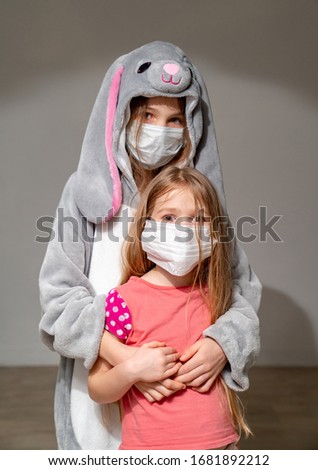 sad kids in pajamas and wearing medical masks in quarantine because of the epidemic embrace