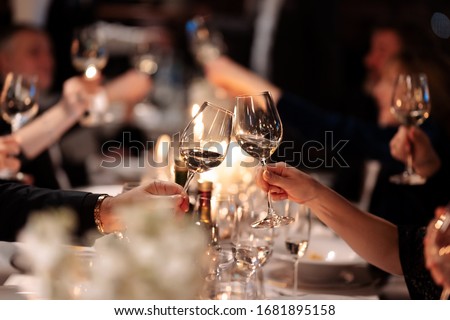 Friends drink wine. Couple toasting wineglasses in a luxury restaurant. Focus on the wineglass. 
Wine brunch. Royalty-Free Stock Photo #1681895158