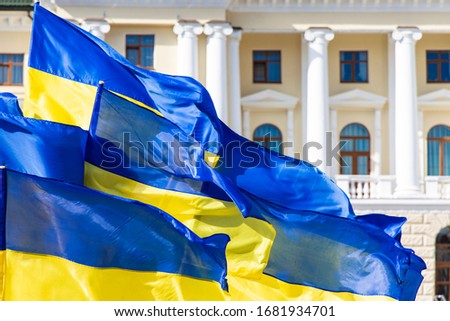 Ukraine flags evolving on a wind government main building architecture facade with columns , independence concept background picture 
