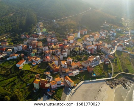 An aerial shot of buildings surrounded by trees in Arou, Galicia, Spain