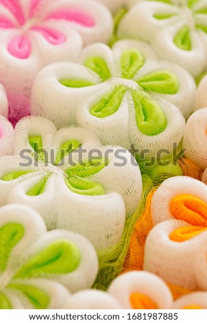 Multi-colored washcloth in the box. Colorful washcloth. Close-up. Flower sponge. Flower-shaped washcloth
