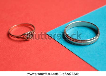 Wedding rings on a red and blue background. Close up.