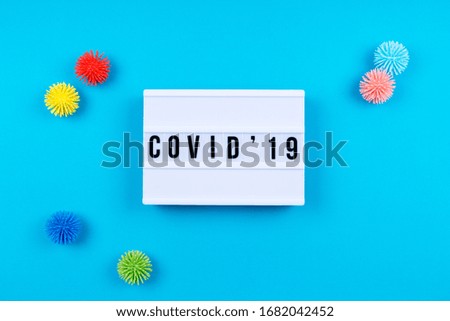 Lightbox with COVID-19 wording and plastic balls aka viruses on the blue background. Epidemic, social isolation, coronavirus COVID-19 concept. Horizontal with copy space