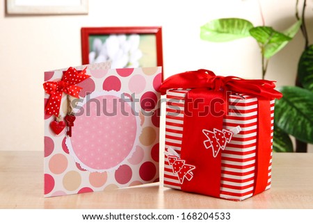 Gift with card on table on room background