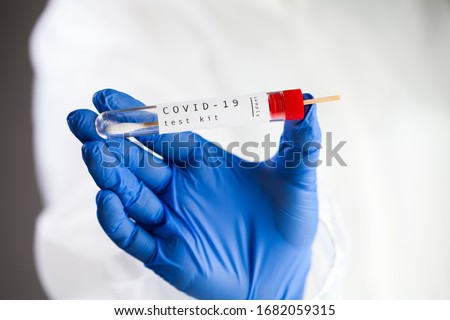 COVID-19 virus disease self swab test sample kit,UK NHS medical laboratory scientist holding plastic throat test swab viral specimen collection equipment tube,Coronavirus OMICRON PCR antigen check  Royalty-Free Stock Photo #1682059315