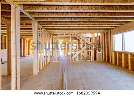 Building construction, wood framing new home under construction roof being built against blue sky Royalty-Free Stock Photo #1682059594