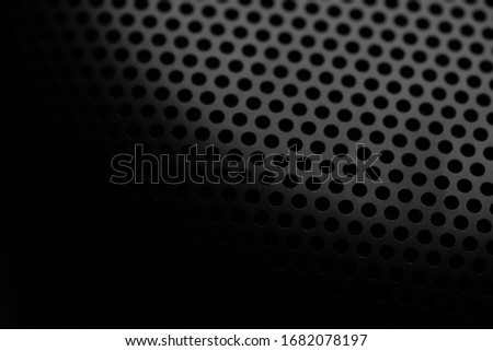 Metallic background with perforation of round holes. Black metal texture with round holes. Industrial background.