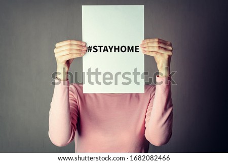 Call to stay home during a coronavirus epidemic to protect against the virus. Covid-19 outbreak concept. Anonymous woman covering face with white paper sheet with hashtag stayhome Royalty-Free Stock Photo #1682082466