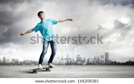 Skater in jeans riding on road against city background
