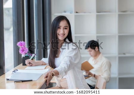 A female student with a happy reading while sitting at cafe background