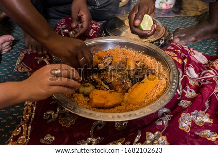 People Eating Traditional Mauritanian Meal with Hands Royalty-Free Stock Photo #1682102623