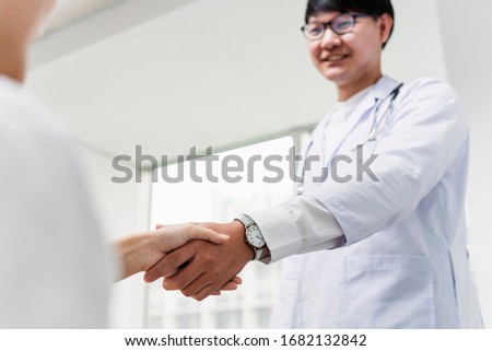 Cropped image of doctor's hand and patient's hand while they do the hand shaking after consultation and treatment.