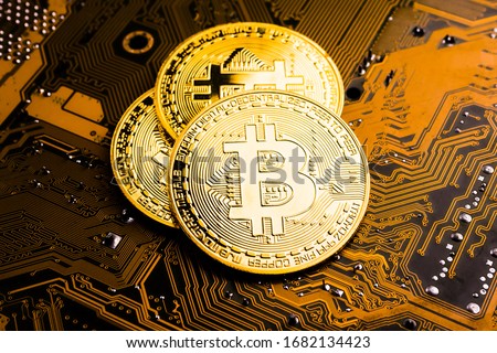 Golden coins with bitcoin symbol on a mainboard. Royalty-Free Stock Photo #1682134423