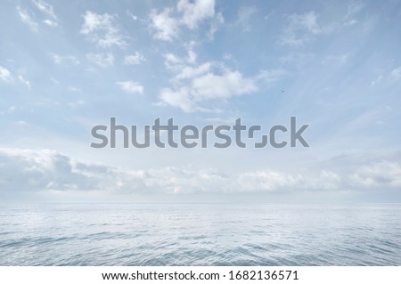 Blue sea and sky. White clouds. Hardly visible horizon line. Seascape. Abstract nature background