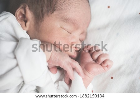 Newborn baby sleeping on bed.Family and love concept.Asian kid.