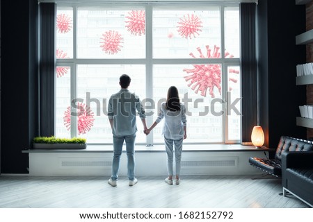 Coronavirus quarantine concept. Man and woman are keeping together their hands looking and scared about covid viruses outside. Stay at home self isolation. Royalty-Free Stock Photo #1682152792