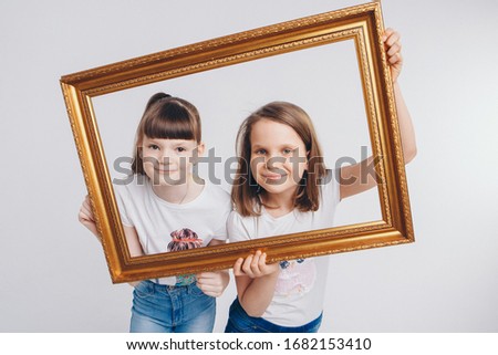 the concept of a healthy lifestyle , child protection, shopping - these are teenagers playing together. Happy children: sisters on a white background. Live picture - the girls look out of the frame