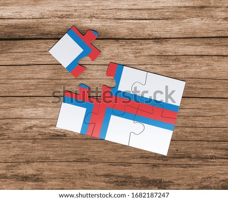 Faroe Islands national flag on jigsaw puzzle. One piece is missing. Danger concept.