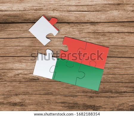 Madagascar national flag on jigsaw puzzle. One piece is missing. Danger concept.
