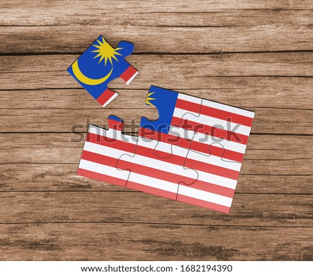 Malaysia national flag on jigsaw puzzle. One piece is missing. Danger concept.