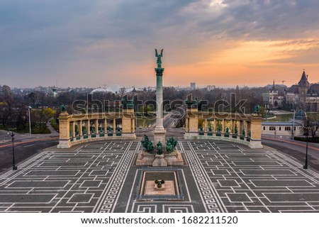 Budapest, Hungary - Aerial view of the totally empty Heroes' Square during the 2020 Coronavirus quarantine in the morning. Vajdahunyad Castle and City Park at background with a warm sunrise Royalty-Free Stock Photo #1682211520