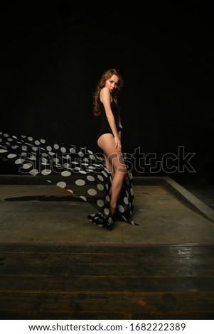 girl in black with black pareo posing on a black background