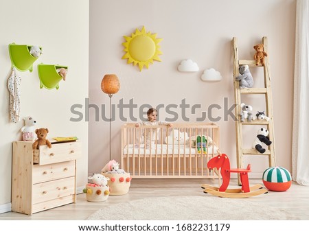 Baby in the wooden cradle and decorative modern room style.